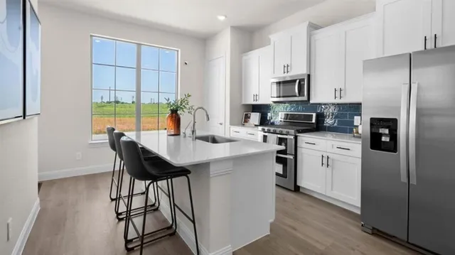 a kitchen with stainless steel appliances a stove a sink refrigerator and a view of wooden cabinets