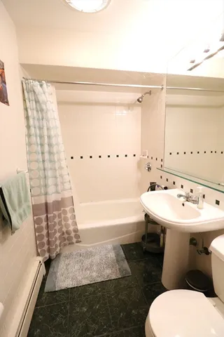 a bathroom with a sink and mirror with bathtub