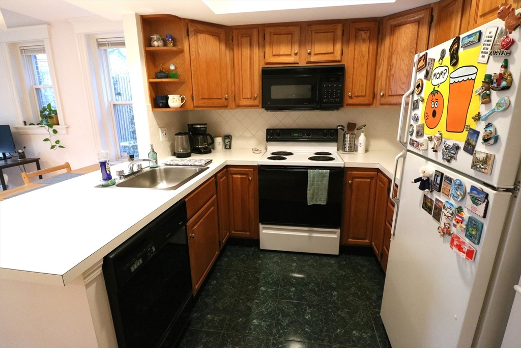 30 Upland Road, Unit 4 Cambridge, MA 02140 - Photo 4 of 14 a kitchen with stainless steel appliances a stove sink microwave and cabinets