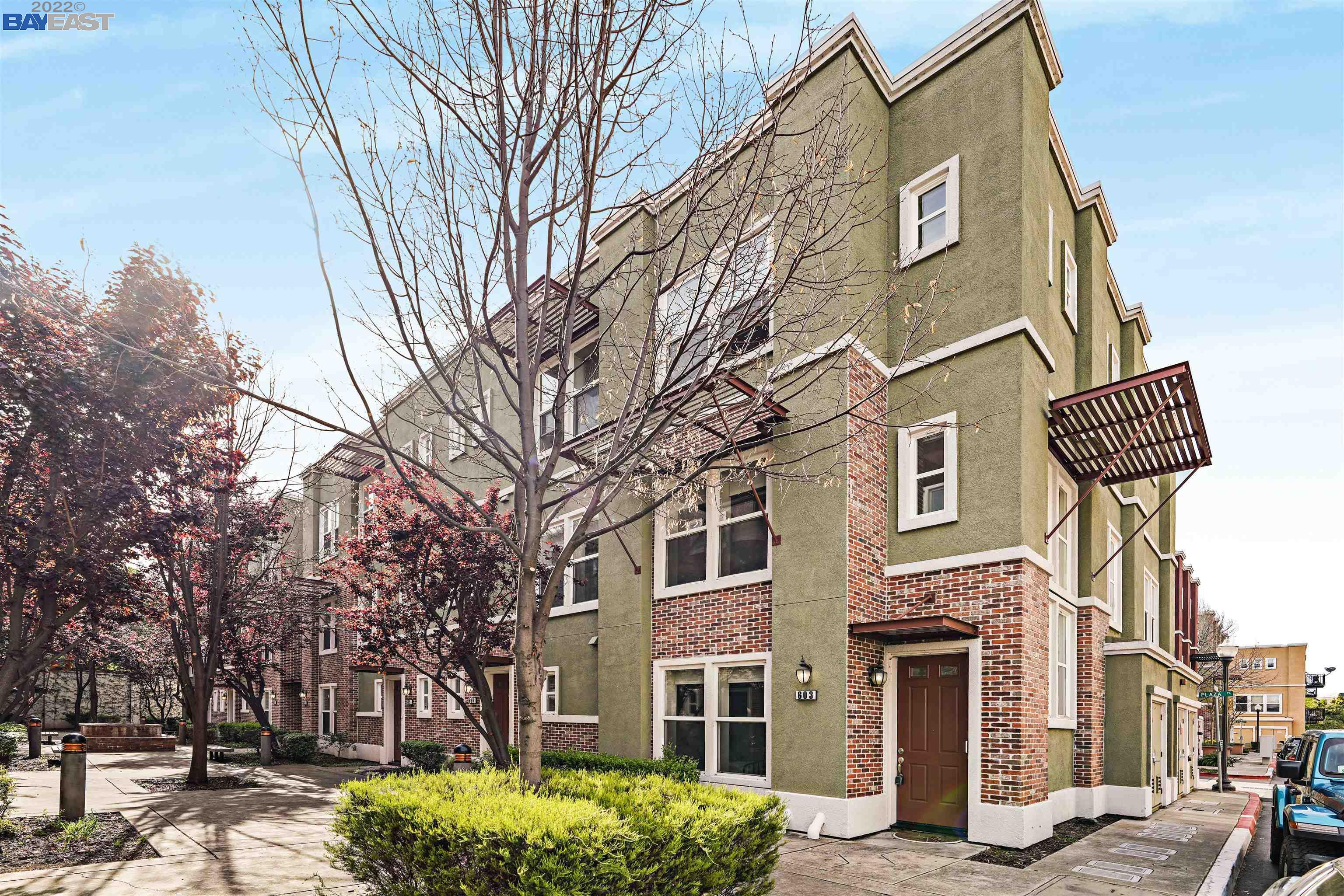 a front view of a building with large trees