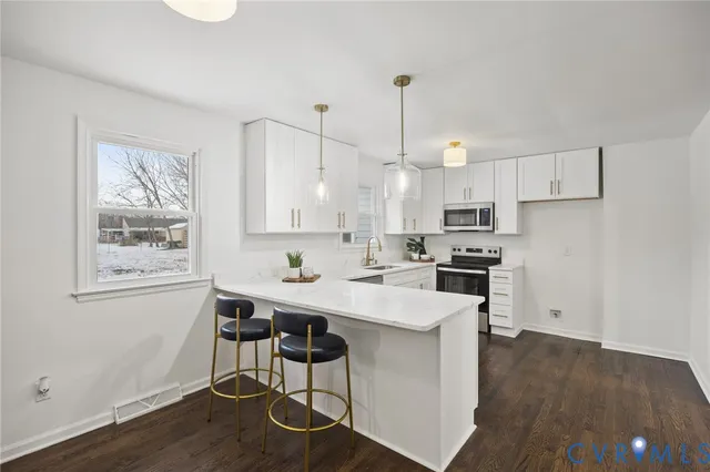 a kitchen with stainless steel appliances a white table chairs and a refrigerator