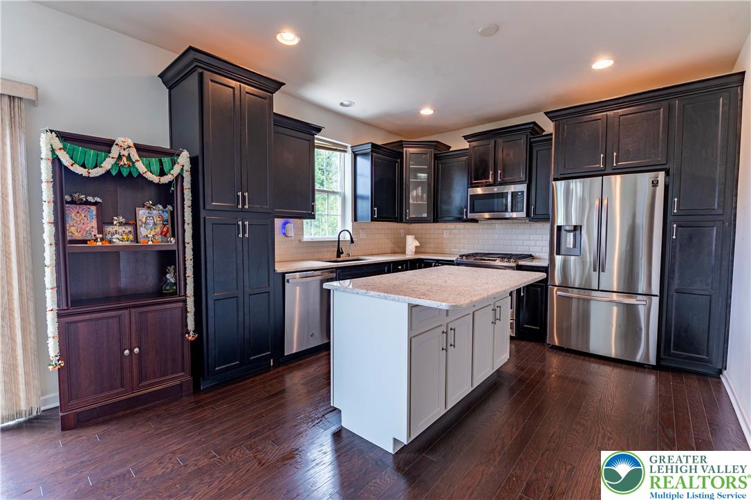 3892 Mink Road Emmaus, PA 18049 - Photo 12 of 39 a kitchen with stainless steel appliances granite countertop a refrigerator a sink and wooden cabinets