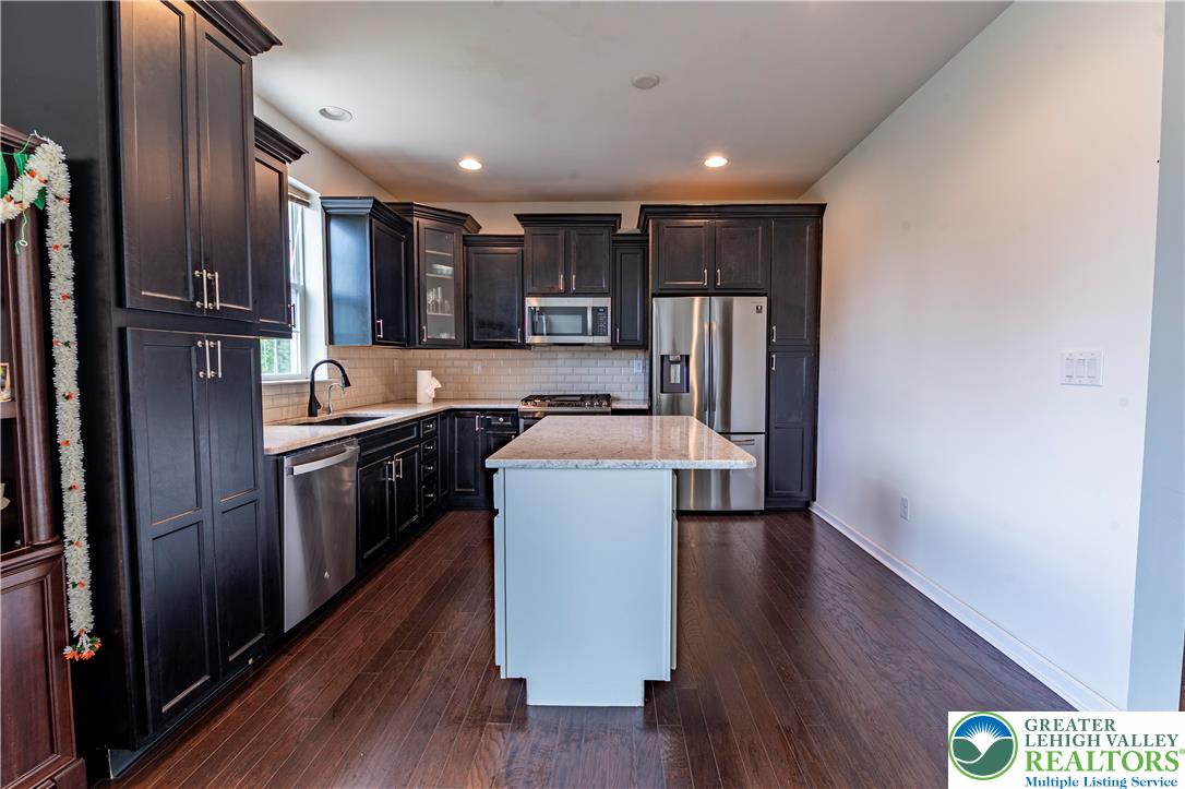 3892 Mink Road Emmaus, PA 18049 - Photo 13 of 39 a kitchen with stainless steel appliances granite countertop a refrigerator a sink and a stove with wooden floor