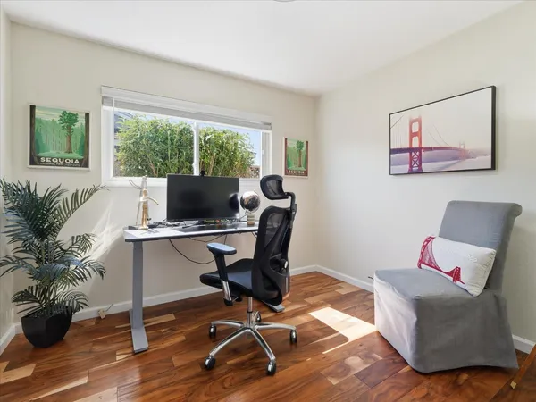 a bedroom with a bed and painting on the wall