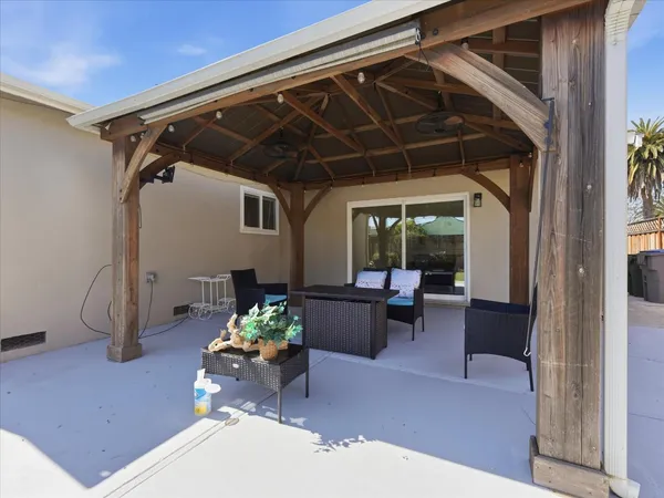 a view of a backyard with couches and a table and chairs with wooden fence