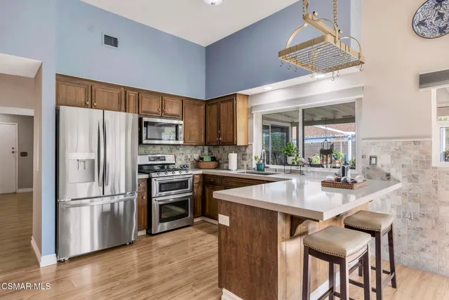 a kitchen with granite countertop a refrigerator stove and sink