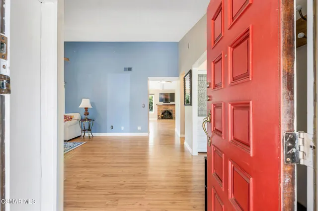 a hallway with wooden floor and a large window
