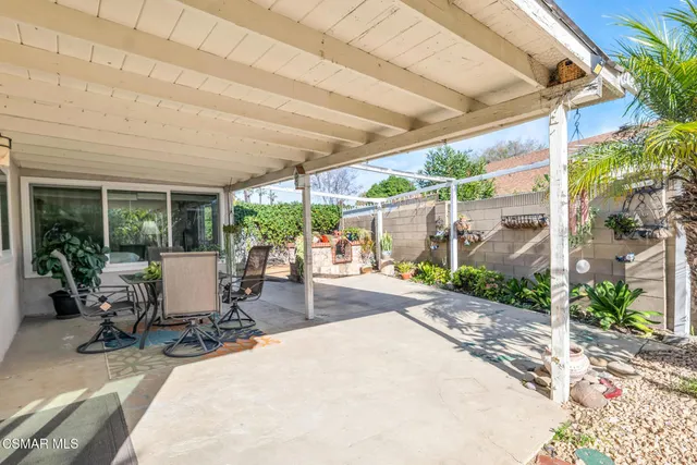 a view of backyard with table and chairs under an umbrella