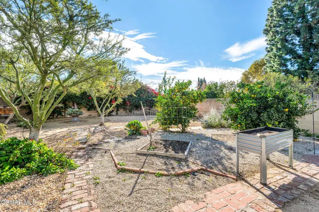 a view of a patio with a table and chairs and a barbeque