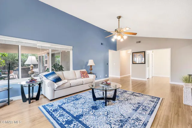 a living room with couches a coffee table and a table with wooden floor