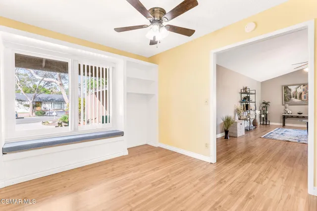 a view of a livingroom with wooden floor and a ceiling fan