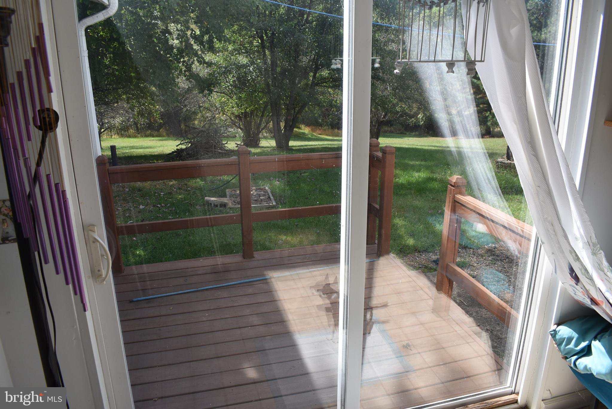 1971 Duckwall Road Berkeley Springs, WV 25411 - Photo 50 of 64 Sunlit deck overlooking a serene backyard.