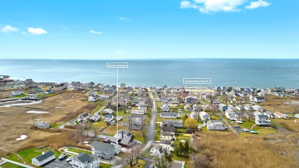 an aerial view of a city with ocean view in back