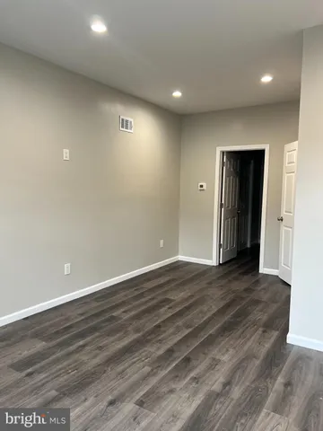 an empty room with wooden floor and closet