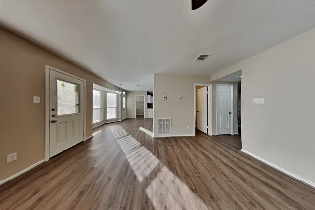 a view of empty room with wooden floor