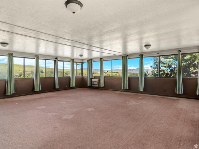 15680 North Beaver Dam Road Collinston, UT 84306 - Photo 22 of 49 Sunroom featuring extensive window-lines, wall-to-wall carpeting, and multiple ceiling-mounted light fixtures