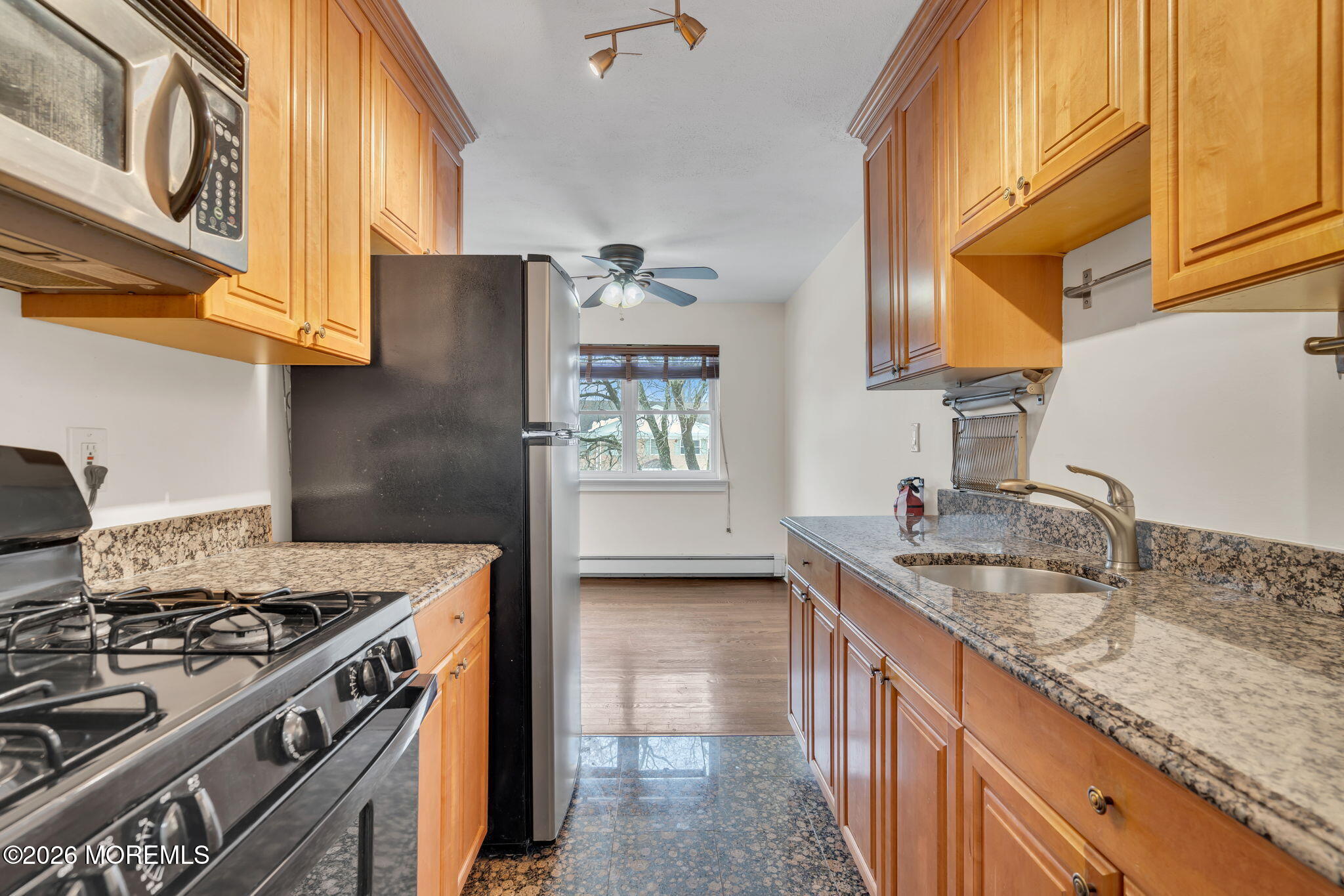 26 Windsor Terrace, Unit E Freehold, NJ 07728 - Photo 11 of 20 a kitchen with granite countertop a sink stove and refrigerator