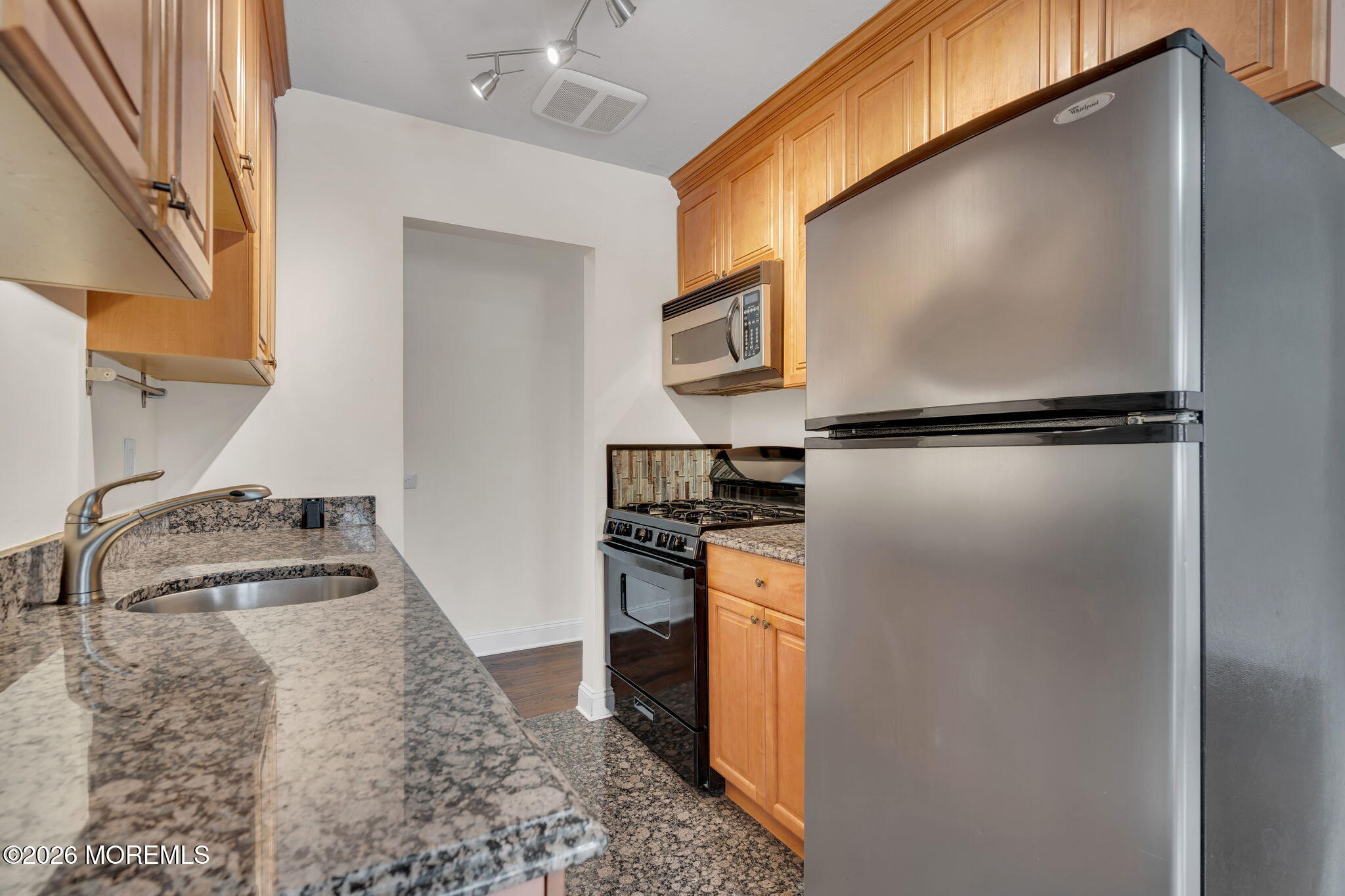 26 Windsor Terrace, Unit E Freehold, NJ 07728 - Photo 14 of 20 a kitchen with a refrigerator and a stove