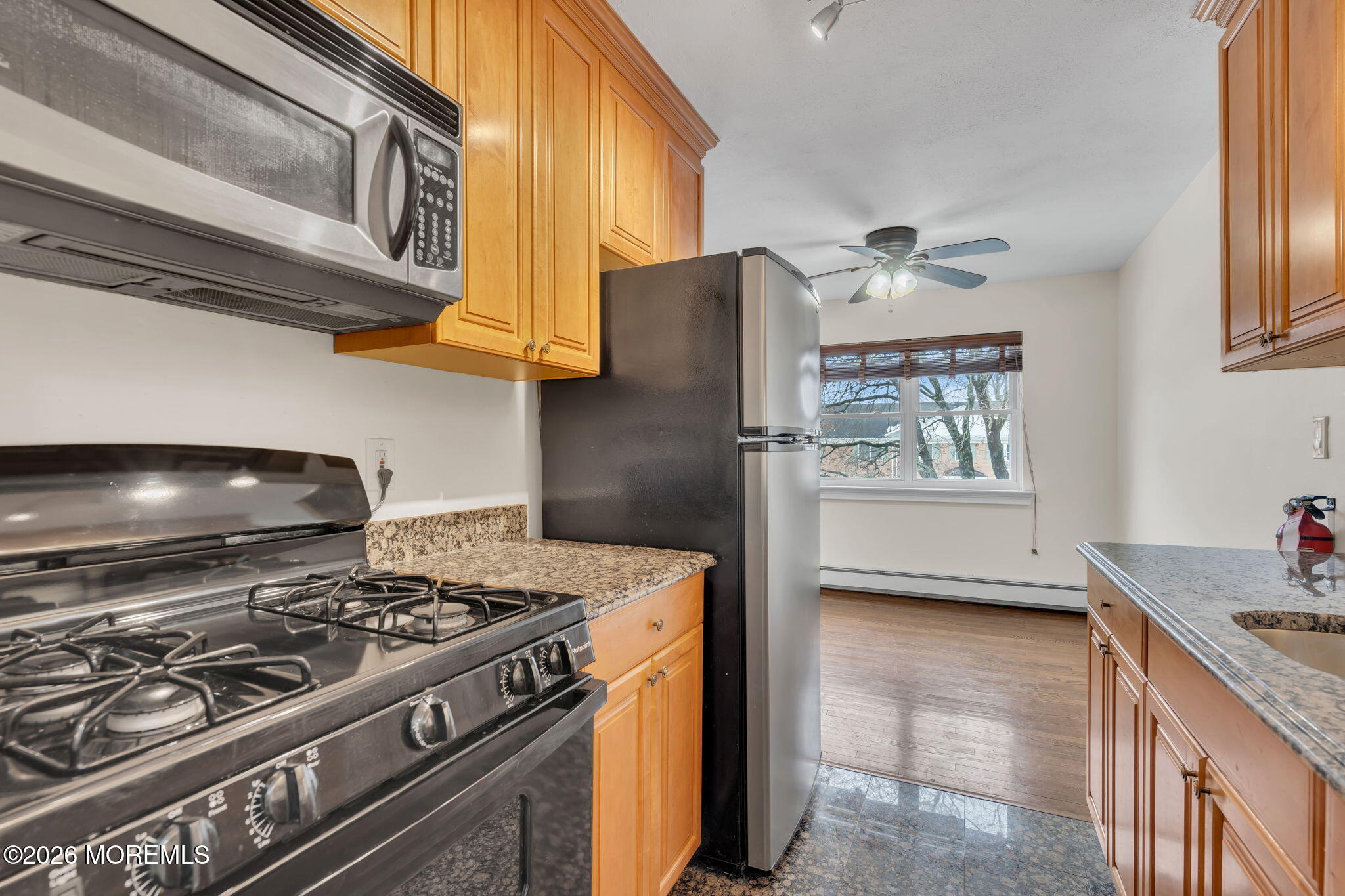 26 Windsor Terrace, Unit E Freehold, NJ 07728 - Photo 15 of 20 a kitchen with stainless steel appliances granite countertop a stove and a refrigerator