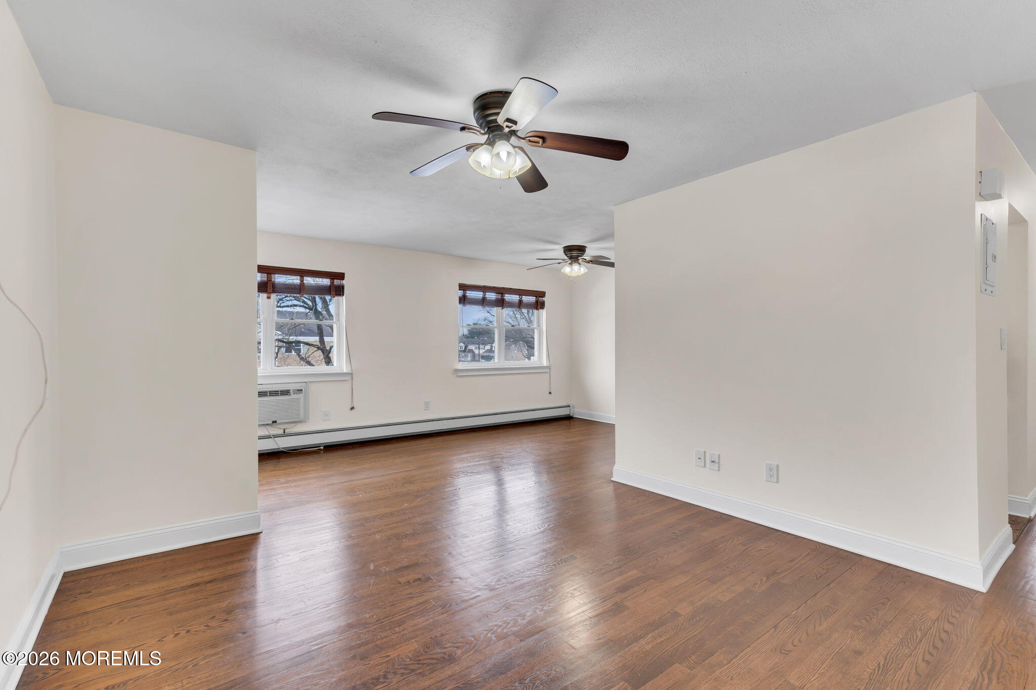 26 Windsor Terrace, Unit E Freehold, NJ 07728 - Photo 2 of 20 a view of an empty room with wooden floor and a ceiling fan