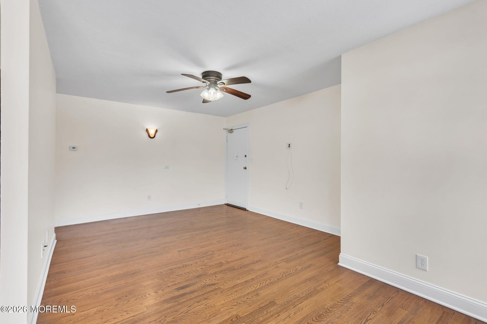 26 Windsor Terrace, Unit E Freehold, NJ 07728 - Photo 3 of 20 an empty room with wooden floor and a ceiling fan