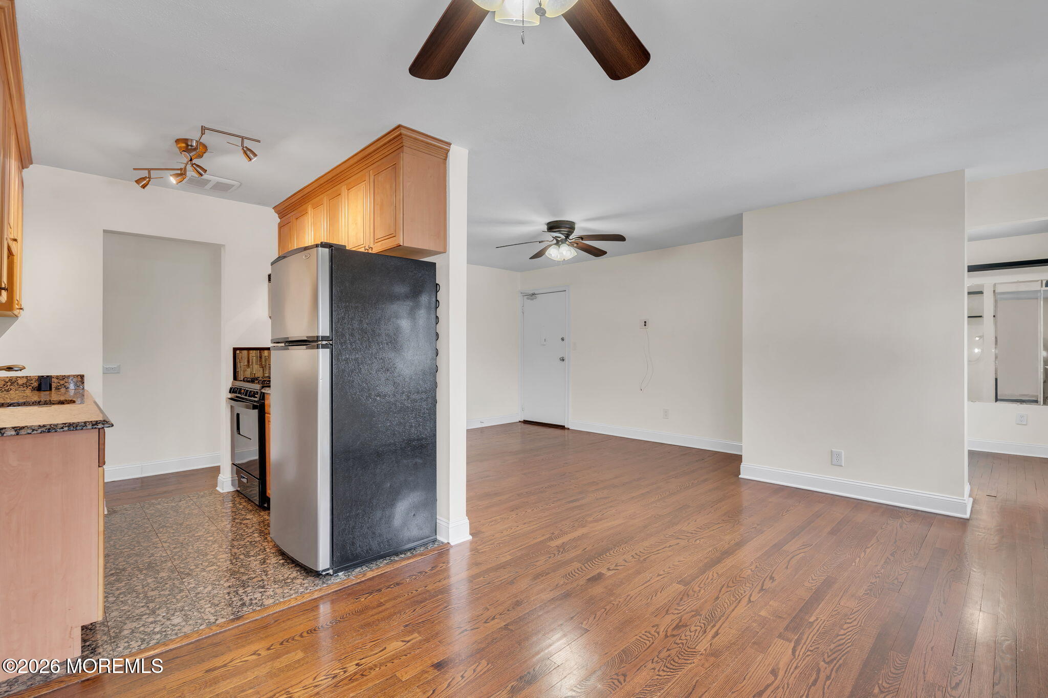 26 Windsor Terrace, Unit E Freehold, NJ 07728 - Photo 5 of 20 an empty room with wooden floor and cabinet