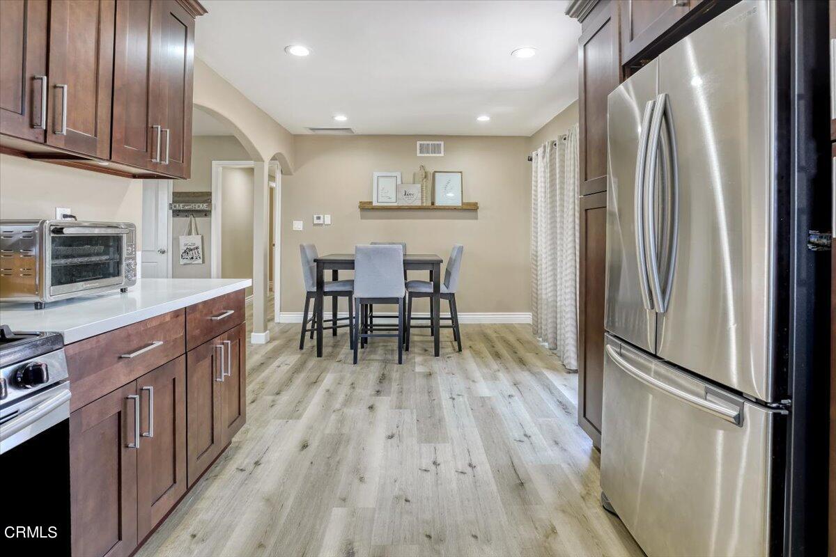 635 Oleander Drive Oxnard, CA 93033 - Photo 15 of 37 a kitchen with stainless steel appliances granite countertop a refrigerator a stove a sink dishwasher and a wooden cabinets with wooden floor