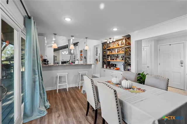 a living room with stainless steel appliances furniture large window and wooden floor
