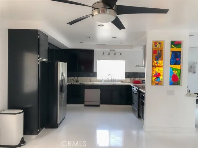 71292 Biskra Road Rancho Mirage, CA 92270 - Photo 7 of 27 a kitchen with stainless steel appliances kitchen island granite countertop a refrigerator and a sink
