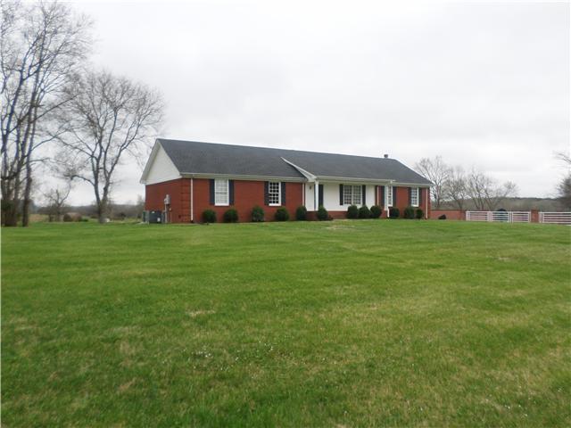 a view of a house with a big yard and large trees