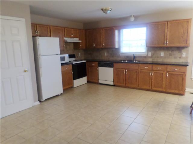 1156 Young Road Lebanon, TN 37090 - Photo 14 of 20 a kitchen with granite countertop a refrigerator a sink a stove a microwave a counter top and cabinets