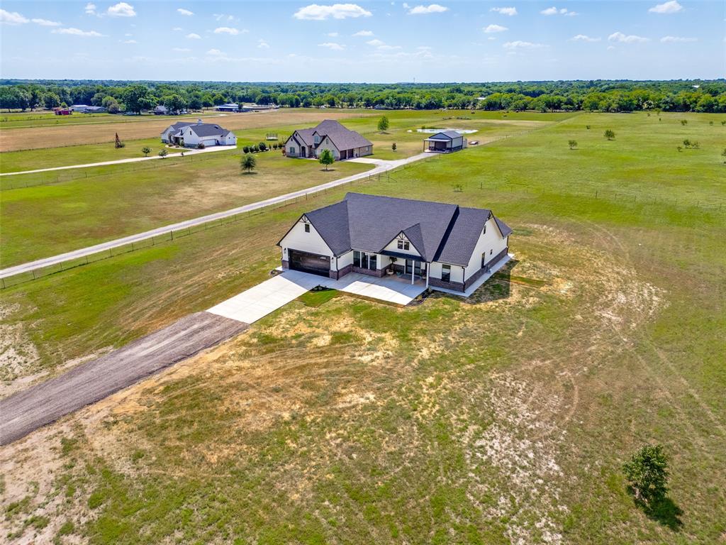 3150 Crisp Road Ennis, TX 75119 - Photo 25 of 30 Contemporary single-story residence featuring a dark shingle roof, light-colored siding, and a stone-look foundation
