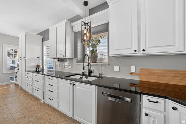 14738 Tangle Hill Road Herriman, UT 84096 - Photo 21 of 66 Modern kitchen featuring white shaker cabinetry, black countertops, a stainless steel dishwasher, and a contemporary pendant light fixture