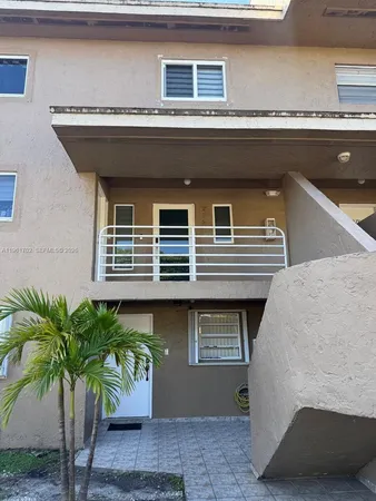 a front view of a house with a potted plant