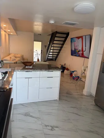 a kitchen with a sink cabinets and wooden floor