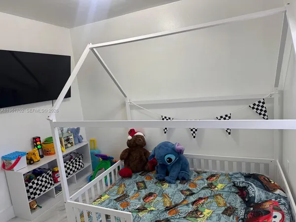 a bed room with two beds and a baby crib