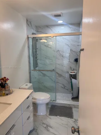a bathroom with a shower toilet and sink