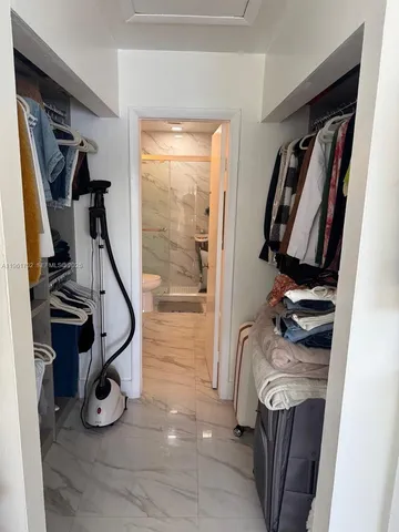 a view of walk in closet with clothes and shoes