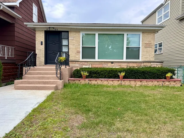 a front view of a house with a garden and plants