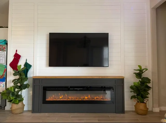 a living room with a fireplace and potted plant