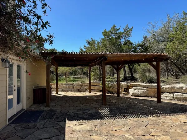 a view of a porch with a table and chairs under an umbrella