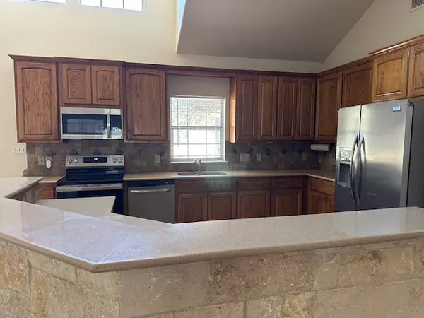 a kitchen with stainless steel appliances a refrigerator sink and cabinets