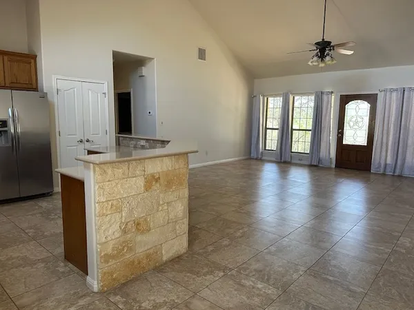 a kitchen with granite countertop a refrigerator and a stove top oven