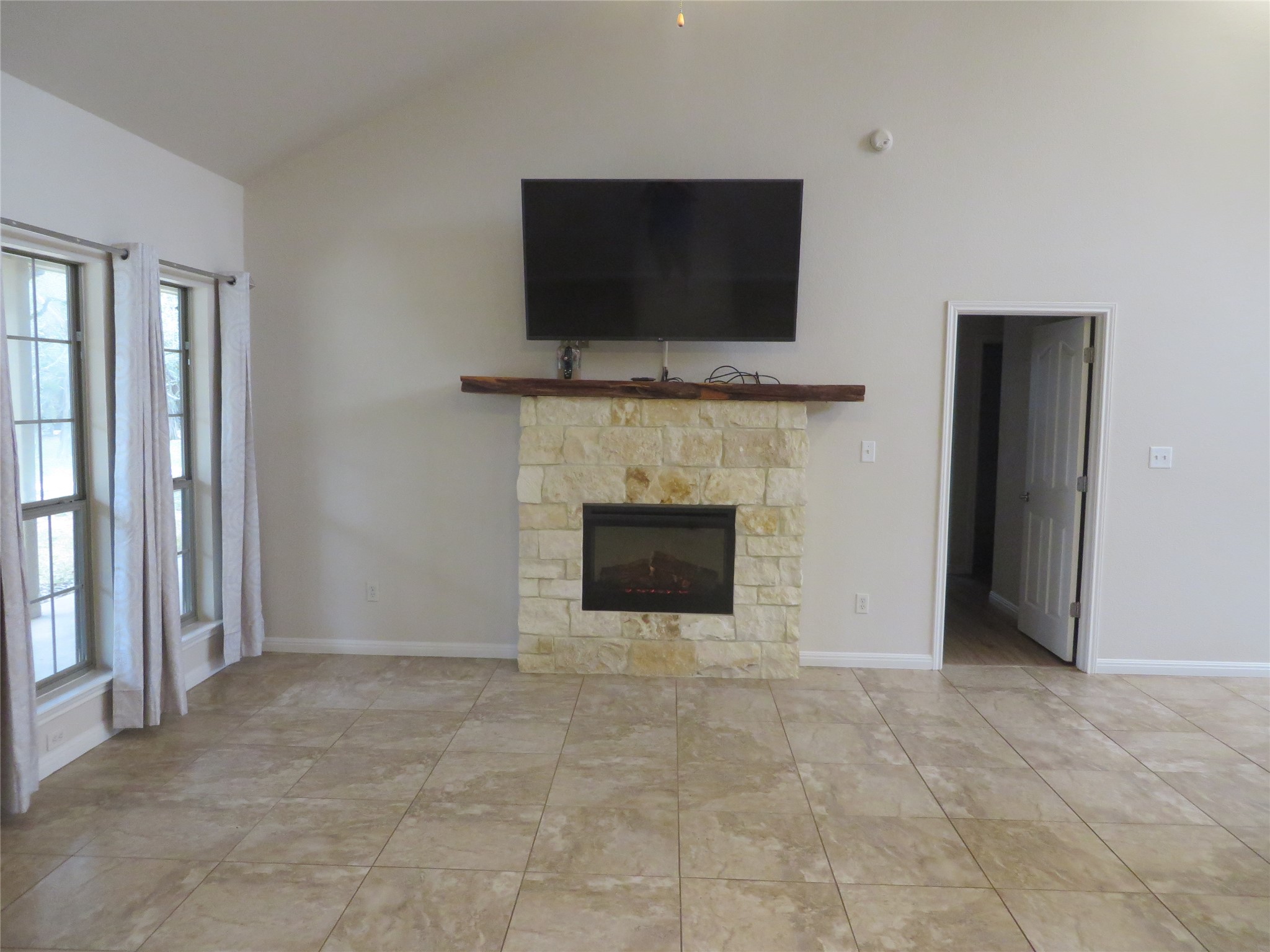 1761 Cottonwood Road Fischer, TX 78623 - Photo 22 of 29 a view of an empty room with a fireplace and a flat screen tv