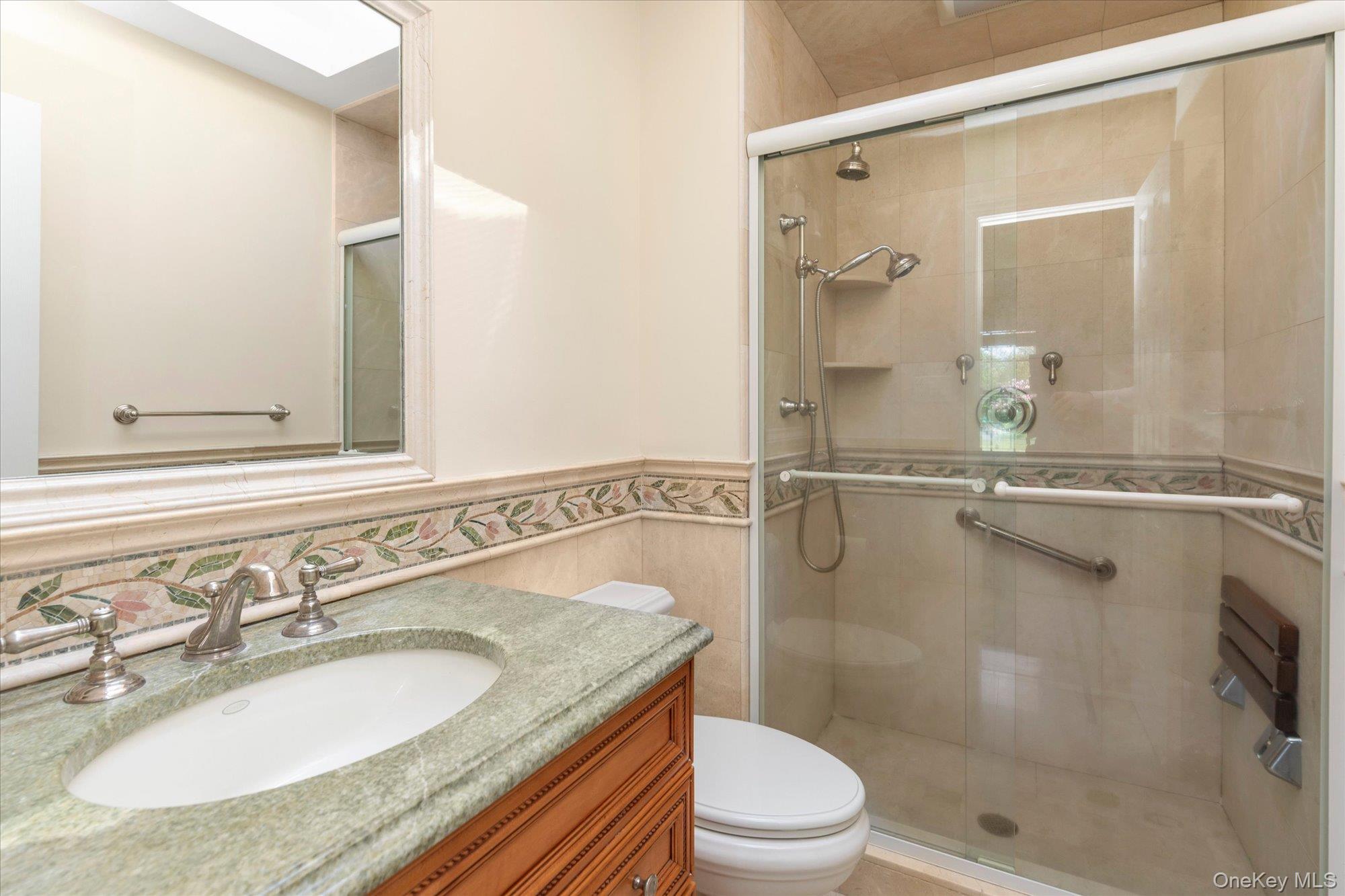 6 Maple Avenue Locust Valley, NY 11560 - Photo 13 of 21 a bathroom with a granite countertop sink toilet a mirror and shower