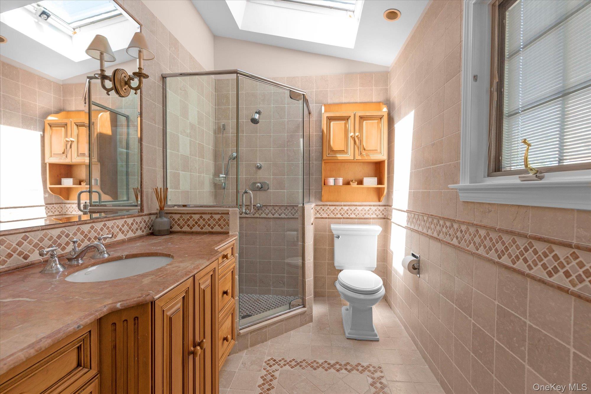 6 Maple Avenue Locust Valley, NY 11560 - Photo 17 of 21 a bathroom with a sink a toilet a mirror and shower