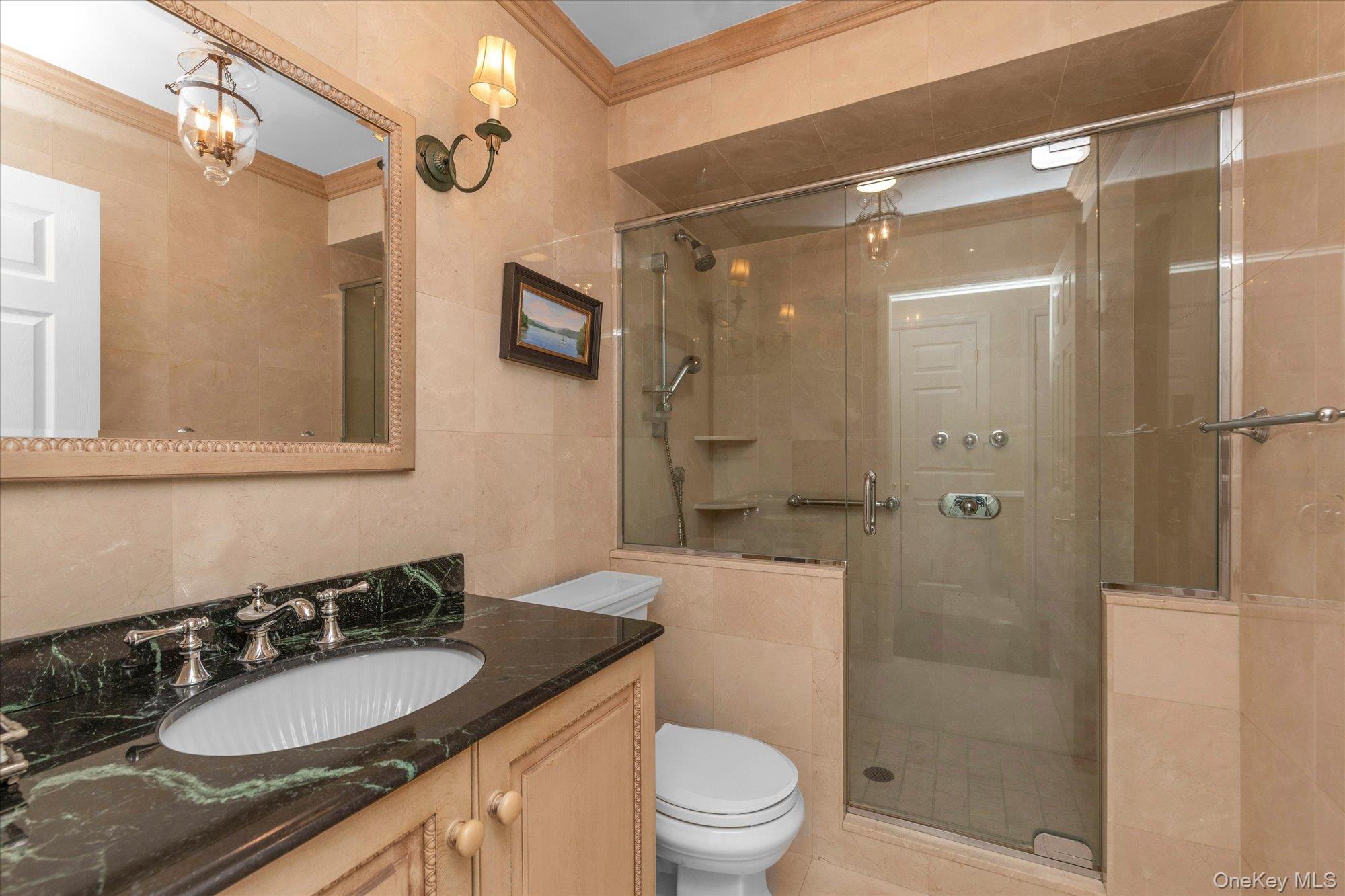 6 Maple Avenue Locust Valley, NY 11560 - Photo 9 of 21 a bathroom with a granite countertop sink toilet a mirror and shower