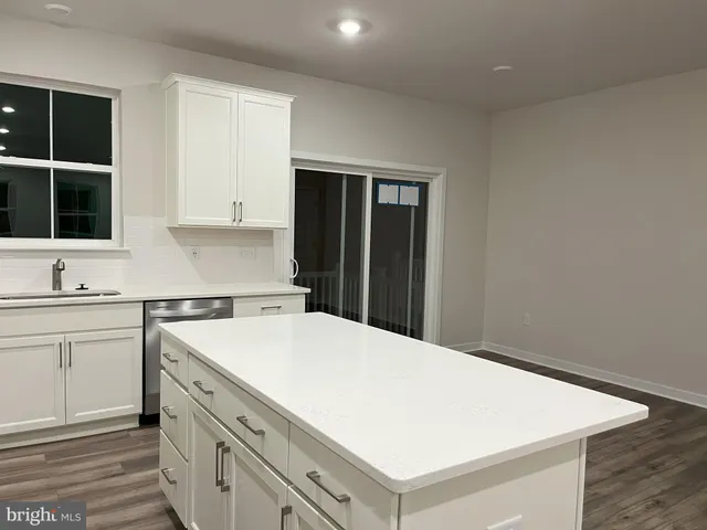 a kitchen with a stove cabinets and wooden floor