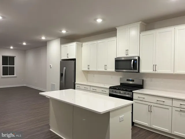 a kitchen with stainless steel appliances a refrigerator sink and microwave