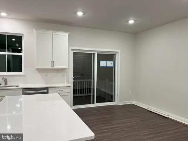 a kitchen with granite countertop a refrigerator and a sink